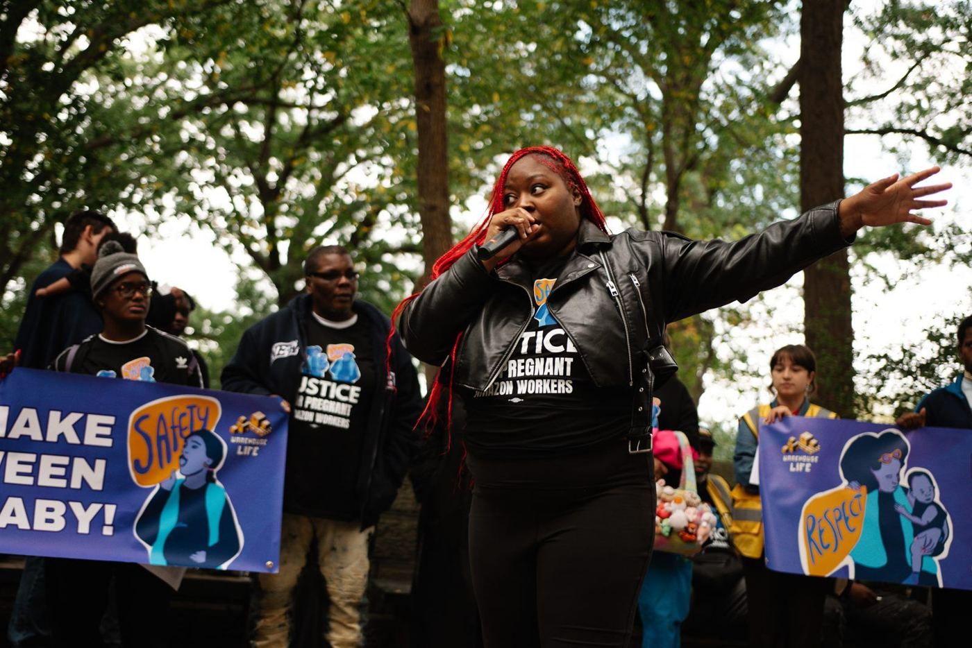 A worker leader speaks into a microphone at a rally